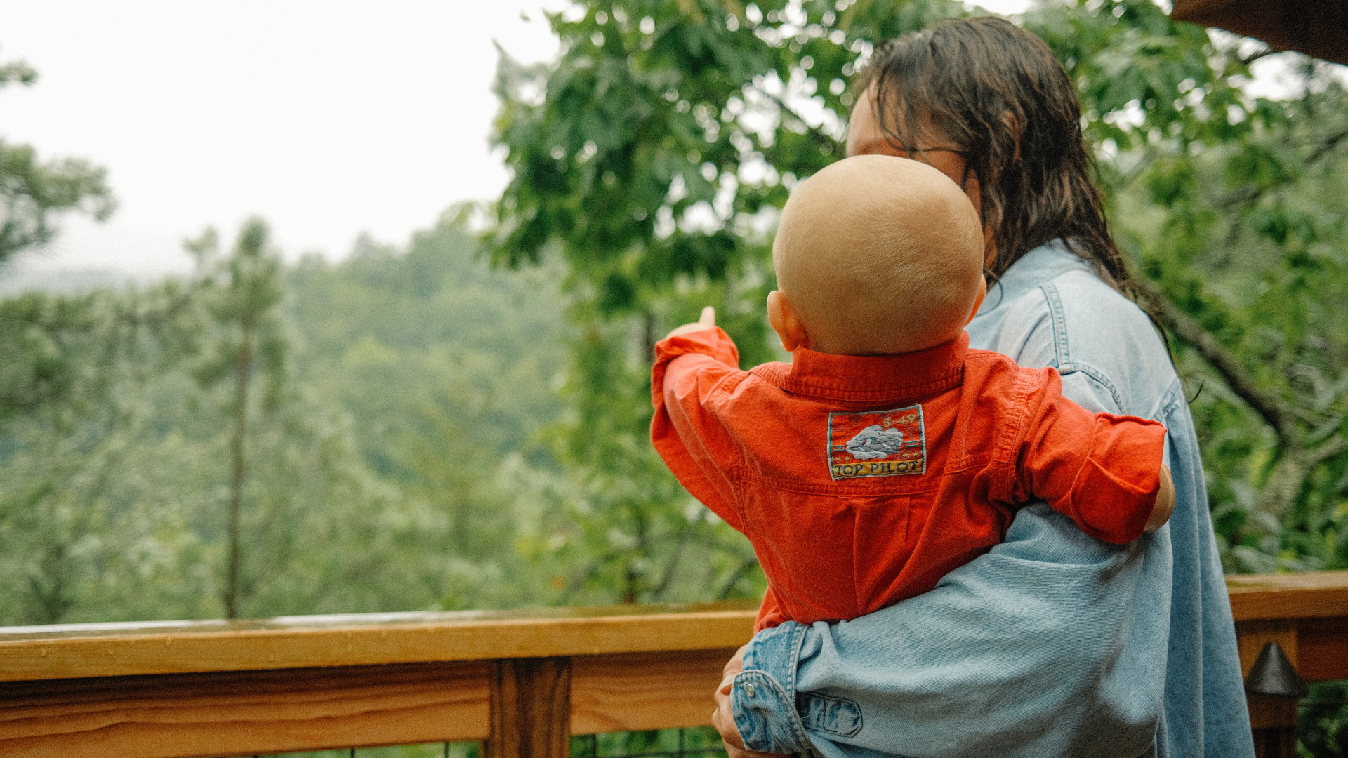 Mother and baby boy who is pointing at the mountains